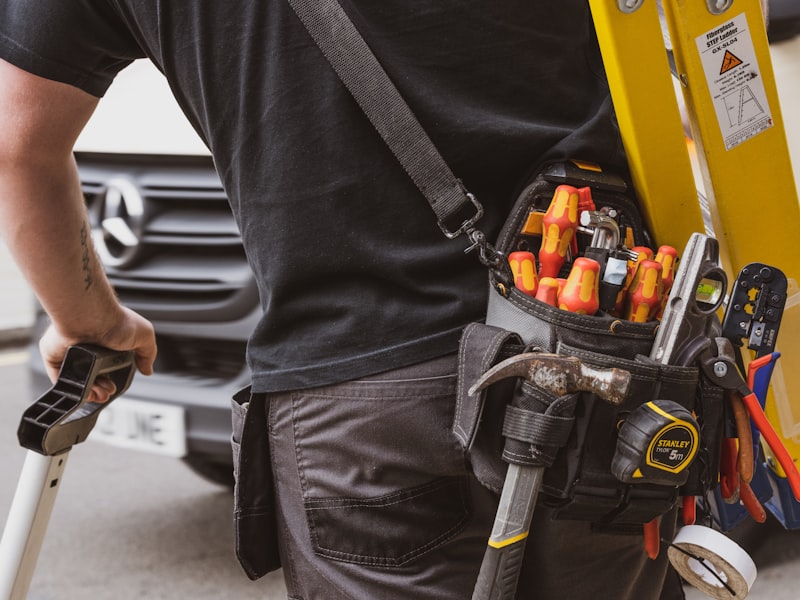 Professional electrician with tools and service van